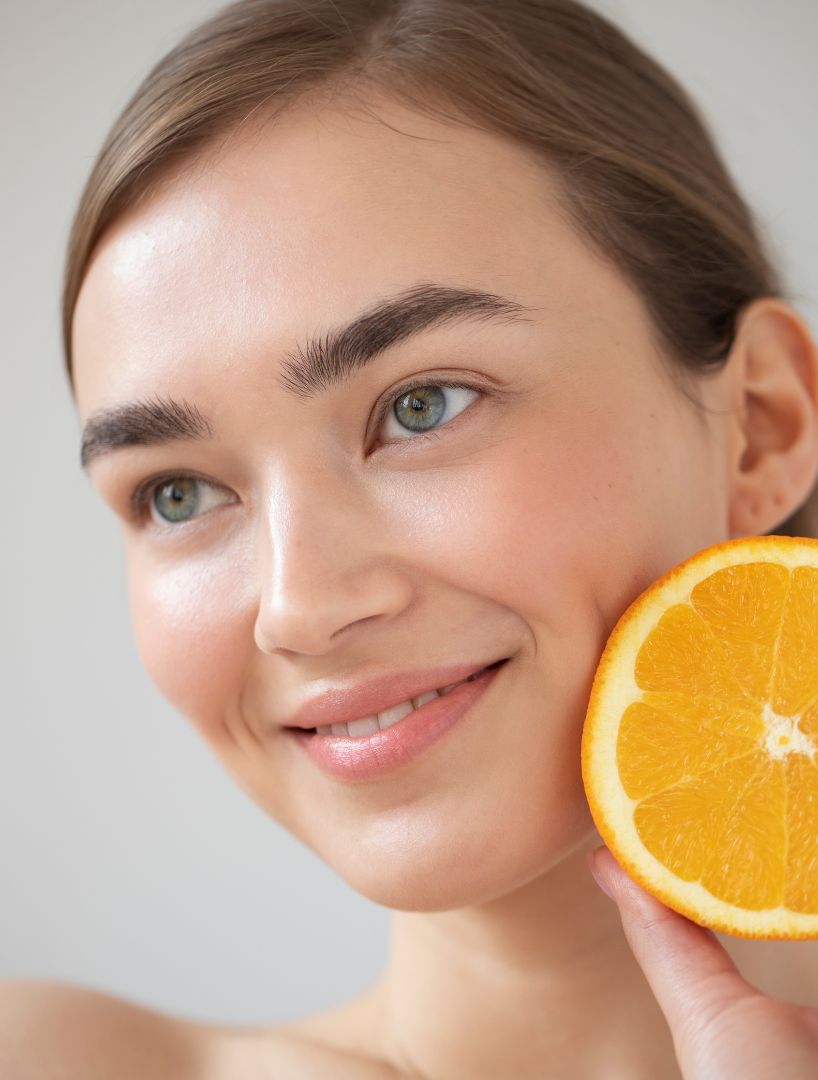 Schöne Frau mit klarer Haut mit geschnittenen Orangen Früchten